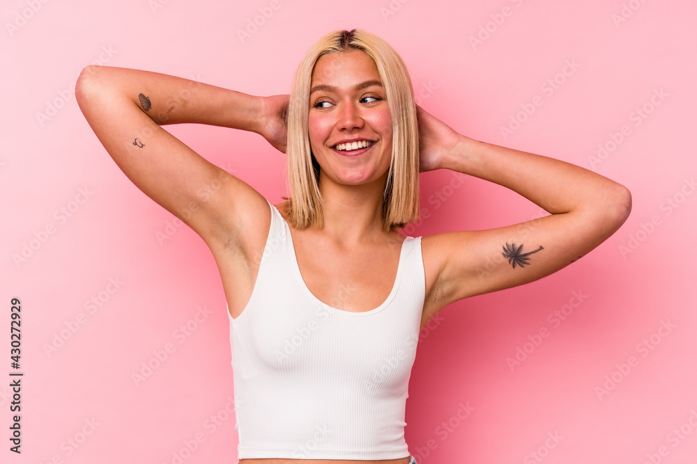 Fototapeta premium Young venezuelan woman isolated on pink background feeling confident, with hands behind the head.