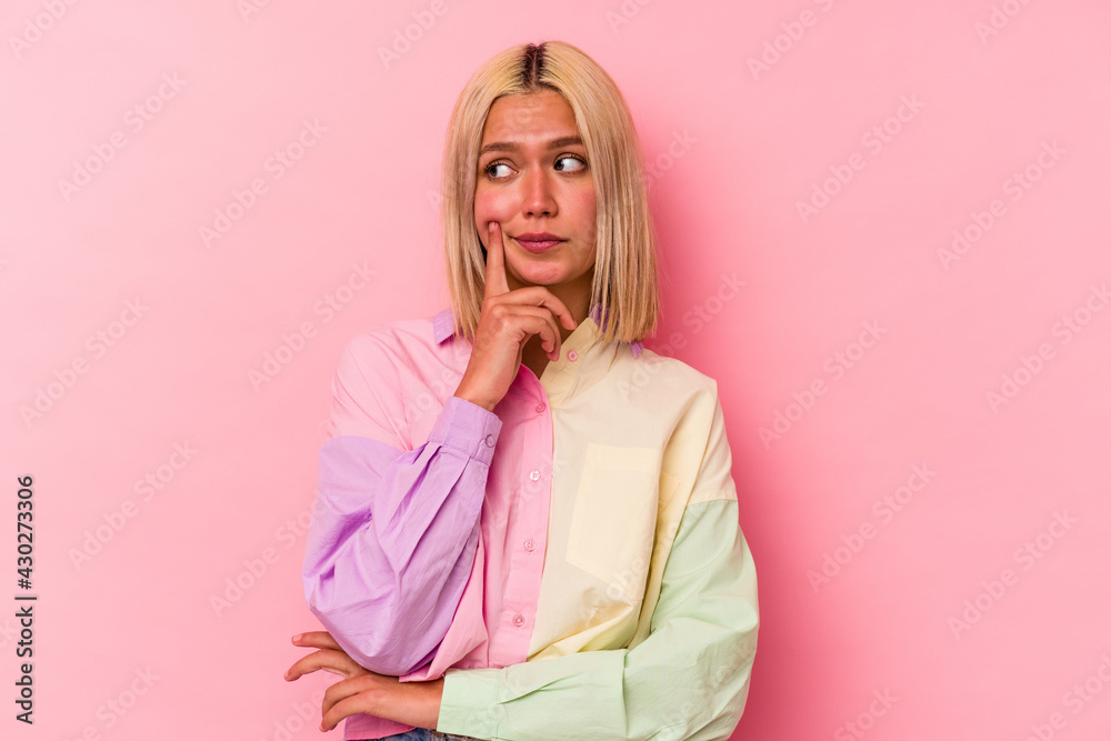 Young venezuelan woman isolated on pink background contemplating, planning a strategy, thinking about the way of a business. Young venezuelan woman isolated on pink background contemplating, planning a strategy, thinking about the way of a business.