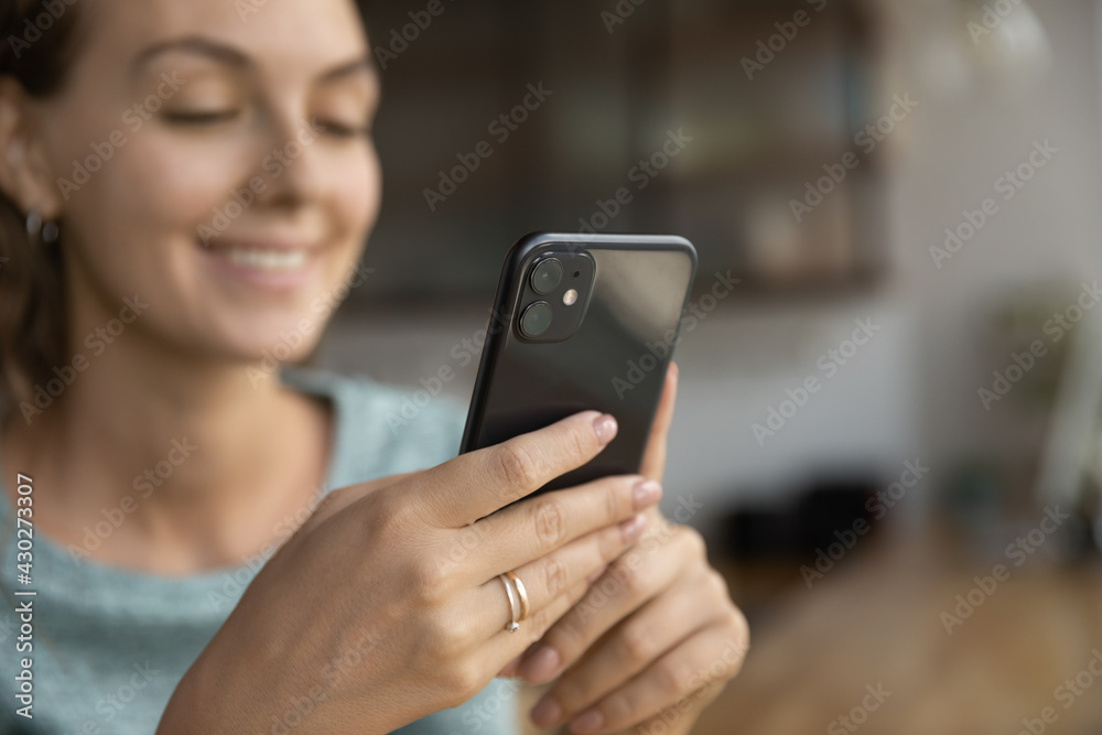 Crop close up of smiling young woman hold modern cellphone gadget browse wireless internet online. Happy female client or user shop on internet, use smartphone text or message. Technology concept.