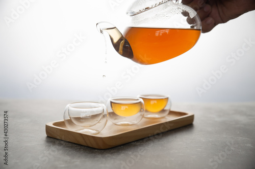 The hot tea is poured into a transparent cup on a white background.