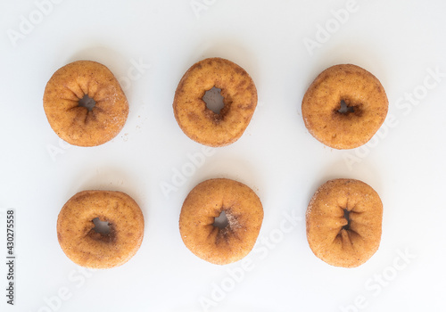 High angle view of six cinnamon donuts on white background