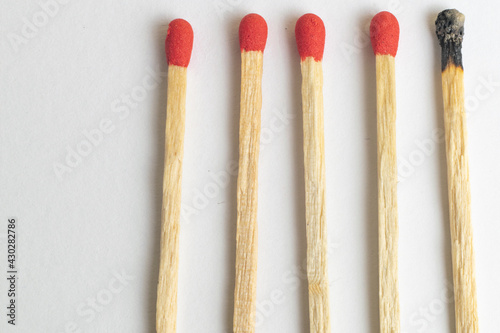Five wooden matches one burned