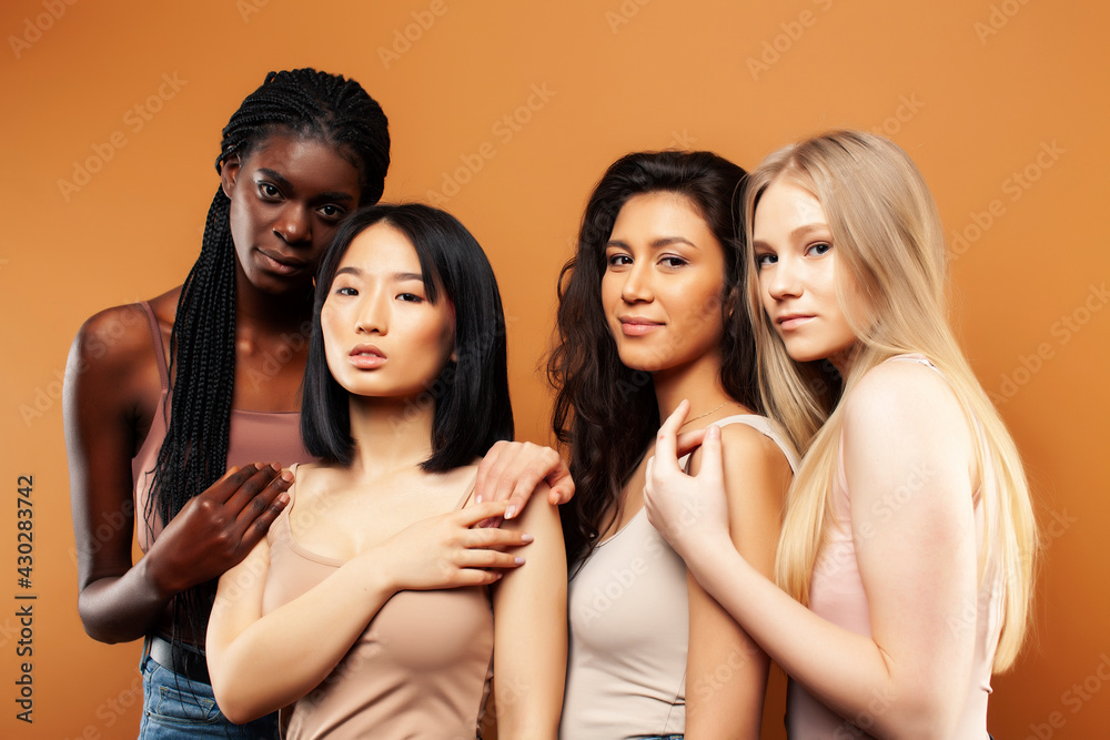Obraz premium young pretty asian, caucasian, afro woman posing cheerful together on brown background, lifestyle diverse nationality people concept