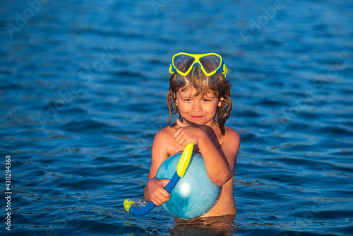Summer resort. Happy child swimming in sea. Kid boy having fun on the beach. Kids summer vacation.
