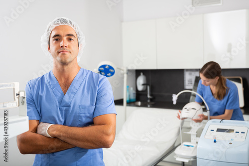 Portrait of confident professional male cosmetologist in modern clinic of aesthetic medicine