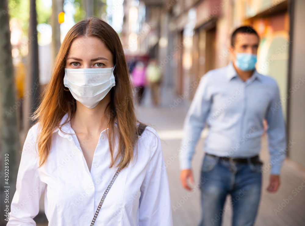 Young woman wearing disposable face mask and gloves for stop spreading of virus disease walking on city street, new normal due to coronavirus outbreak