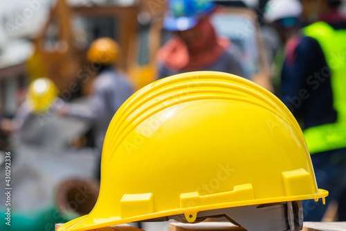 Yellow helmet hard hat safety on table blurry employee background, Labor day concept