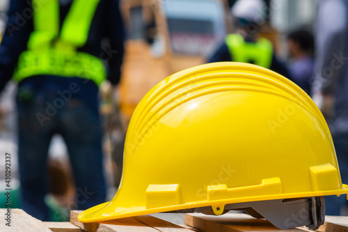 Yellow helmet hard hat safety on table blurry employee background, Labor day concept