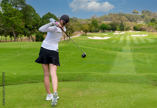 Professional woman golfer teeing golf in golf tournament competition at golf course for winner. 