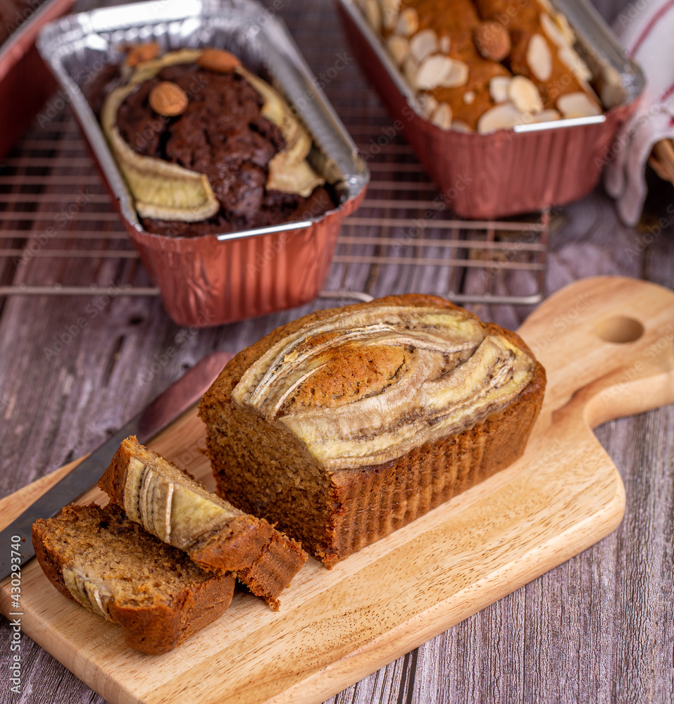 Homemade banana bread sliced with knife on a wooden board close-up. Homemade banana bread sliced with knife on a wooden board close-up.