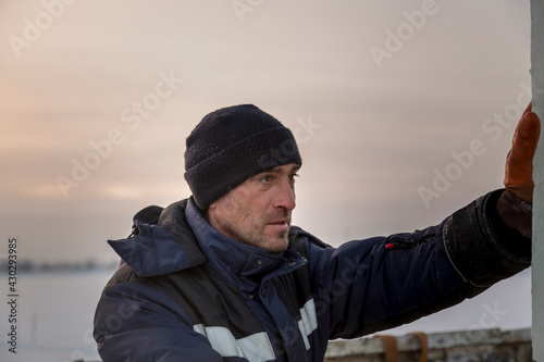 Portrait of a worker in a blue jacket with a hood at a construction site © ads861