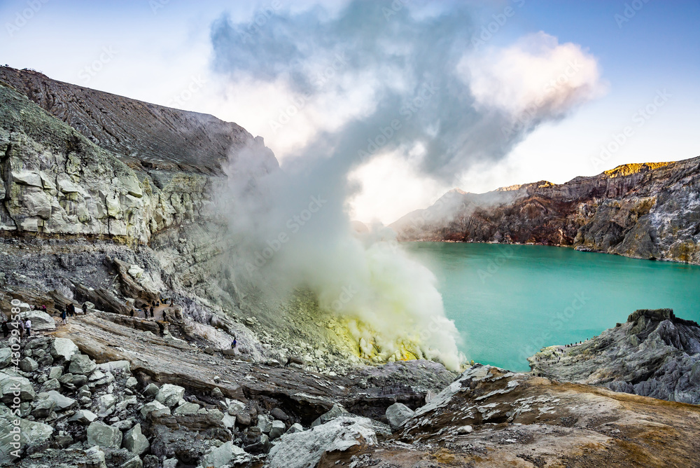 Ijen volcano crater and sulphur mining. Beautiful Landscape mountain and green lake with smoke sulfur in the morning in a Kawah Ijen volcano. Beautiful landmark from East Java, Indonesia