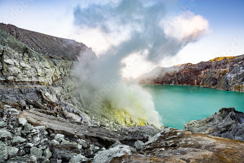 Ijen volcano crater and sulphur mining. Beautiful Landscape mountain and green lake with smoke sulfur in the morning in a Kawah Ijen volcano. Beautiful landmark from East Java, Indonesia © cattyphoto