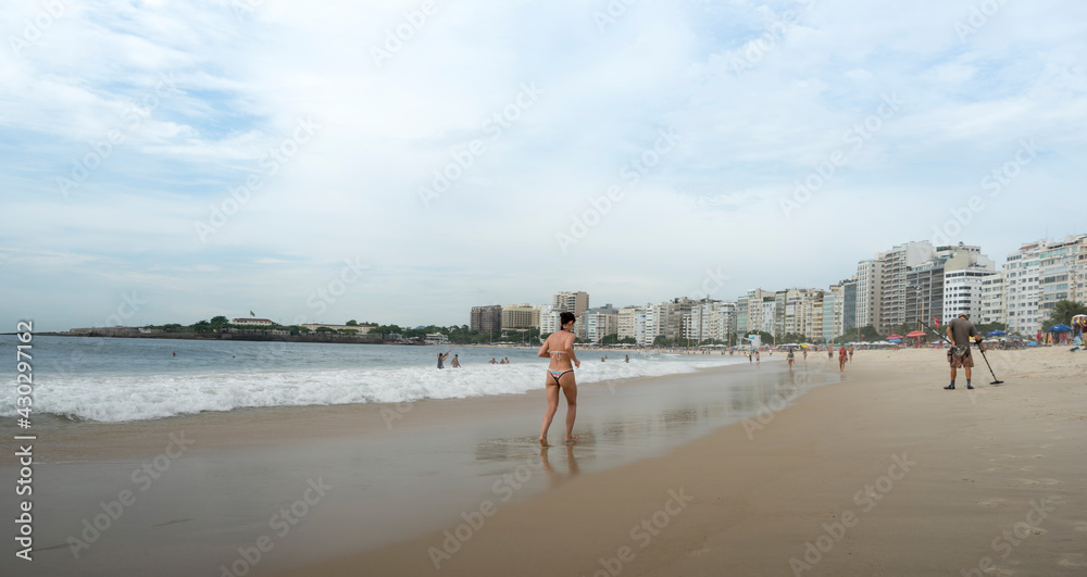 ete running along Copacabana beach.Man looking for metals