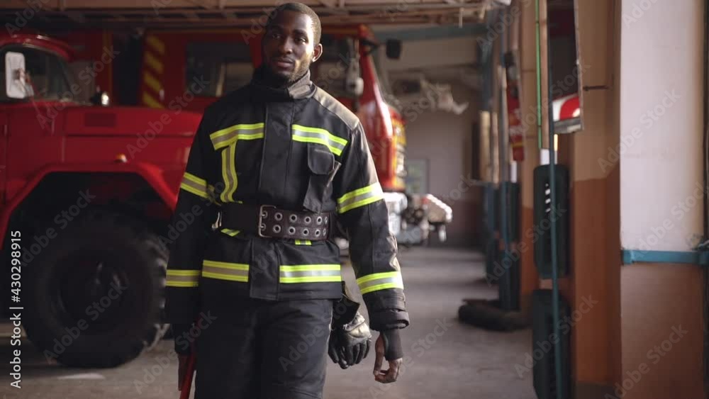 Black fire fighter preparing for emergency call at the station Black fire fighter preparing for emergency call at the station