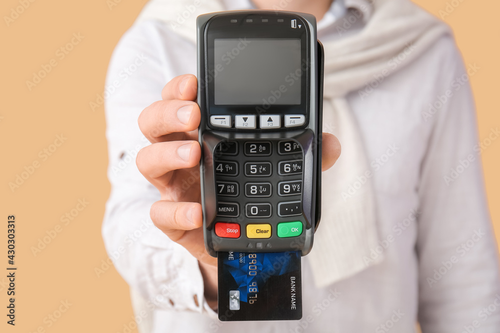 Man with payment terminal on color background, closeup Man with payment terminal on color background, closeup