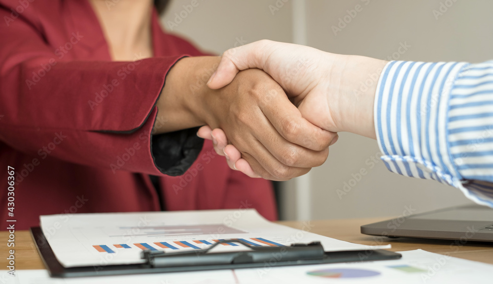Obraz premium Two business leaders talk about charts, financial graphs showing results are analyzing and calculating planning strategies, business success building processes, and shake hands