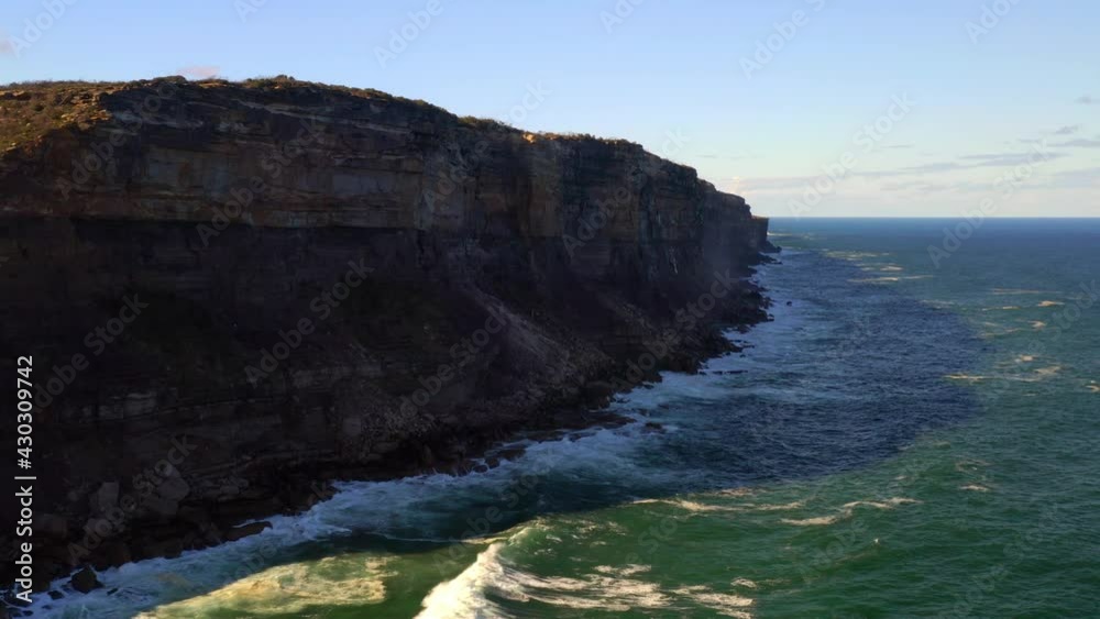Steep Rock Face Plateau With Breaking Waves At Royal National Park Near Sydney In New South Wales, Australia. - Low Aerial Shot Steep Rock Face Plateau With Breaking Waves At Royal National Park Near Sydney In New South Wales, Australia. - Low Aerial Shot