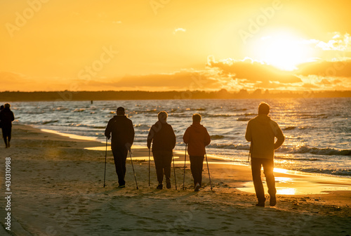 Active and healthy lifestyle. Nordic walking on a sandy beach sea shore