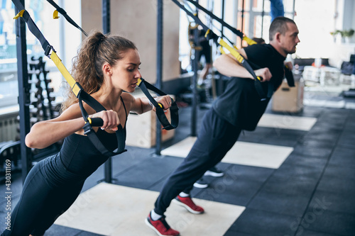 Two young athletic people doing the chest press