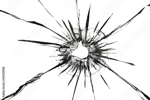 The effect of cracks on broken glass from a shot of a weapon. A hole in the glass of the bullet photo