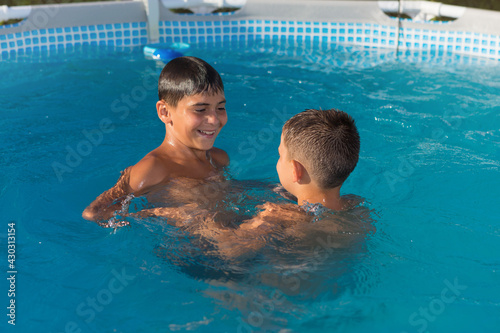 two boys have fun swimming in the pool, blue water, vacation