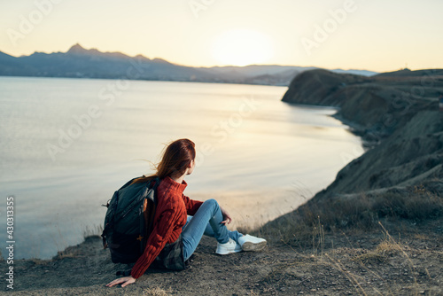 a traveler with a backpack on the sand relaxes in nature near the sea in the mountains © SHOTPRIME STUDIO