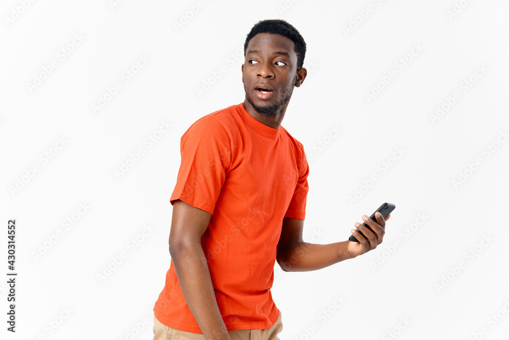 african man orange tshirt mobile phone light background african man orange tshirt mobile phone light background