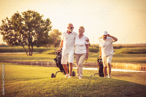 Three senior golfers. Focus is on man and woman. photo