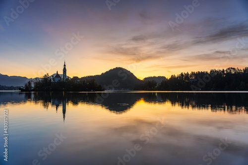 The famous Alpine Lake Bled (Blejsko jezero) in Slovenia, an amazing autumn landscape. Fabulous view of the lake, island with church, Bled Castle, mountains and blue sky with clouds, backdrop in the