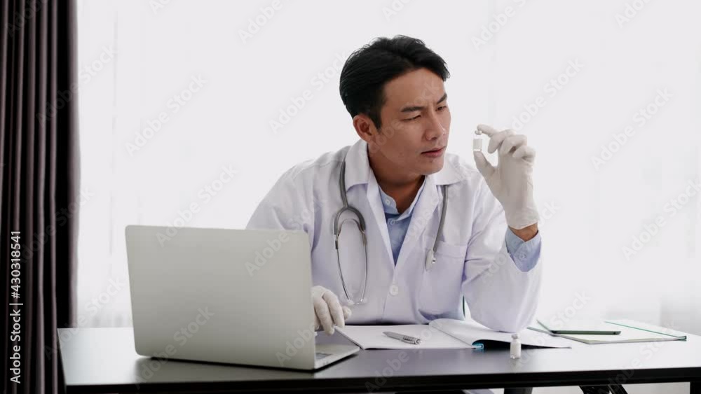 Young Doctor man putting on surgical glove hold vaccine bottle Young Doctor man putting on surgical glove hold vaccine bottle