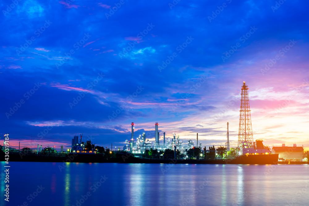 Naklejka premium Oil refinery plant chemical factory and power plant with many storage tanks and pipelines at sunset.