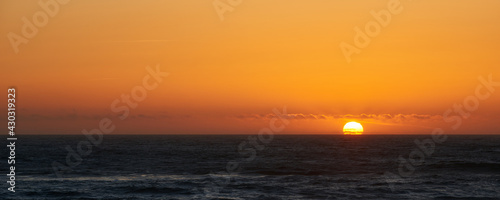 Sunset view and the sun touching the ocean surface near Lincoln city in Oregon.