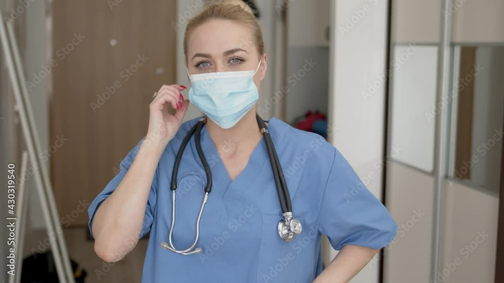 Medical practitioner in mask adjusting stethoscope Medical practitioner in mask adjusting stethoscope