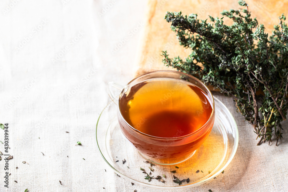 Herbal Thyme tea glass with thymus plant on linen table cloth. Herbal Thyme tea glass with thymus plant on linen table cloth.
