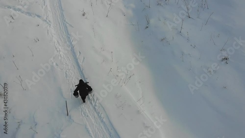 A man carries water from the river in buckets. A hole in the river. Russia, Arkhangelsk region 