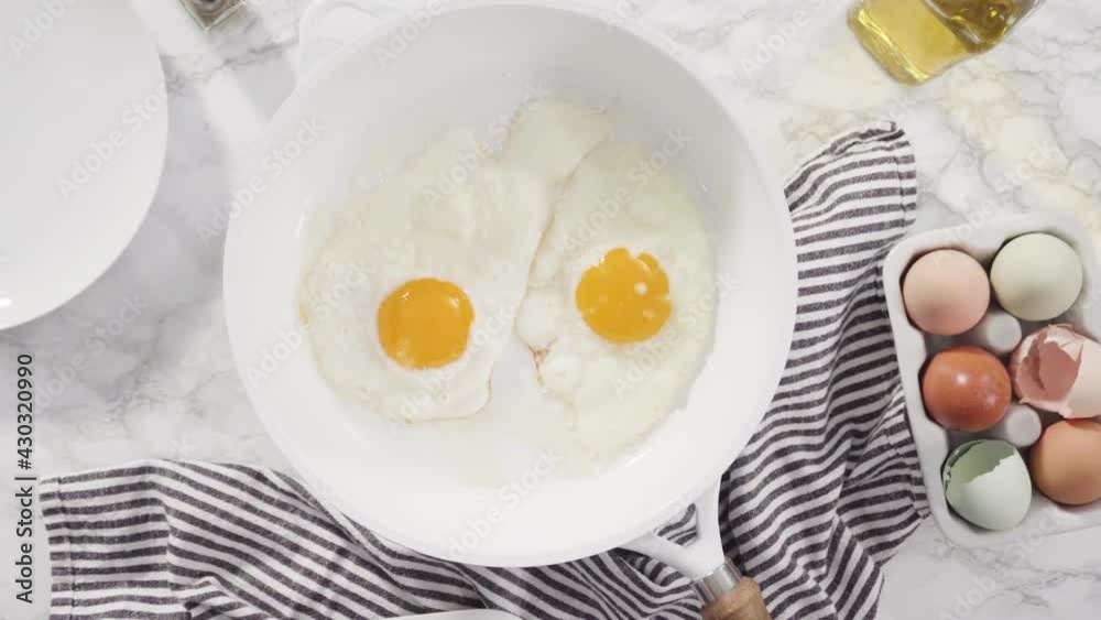 Flat lay. Frying farm fresh eggs in a white skillet. Flat lay. Frying farm fresh eggs in a white skillet.