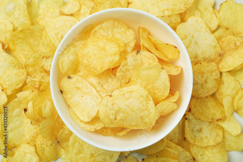 Bowl with tasty potato chips, top view