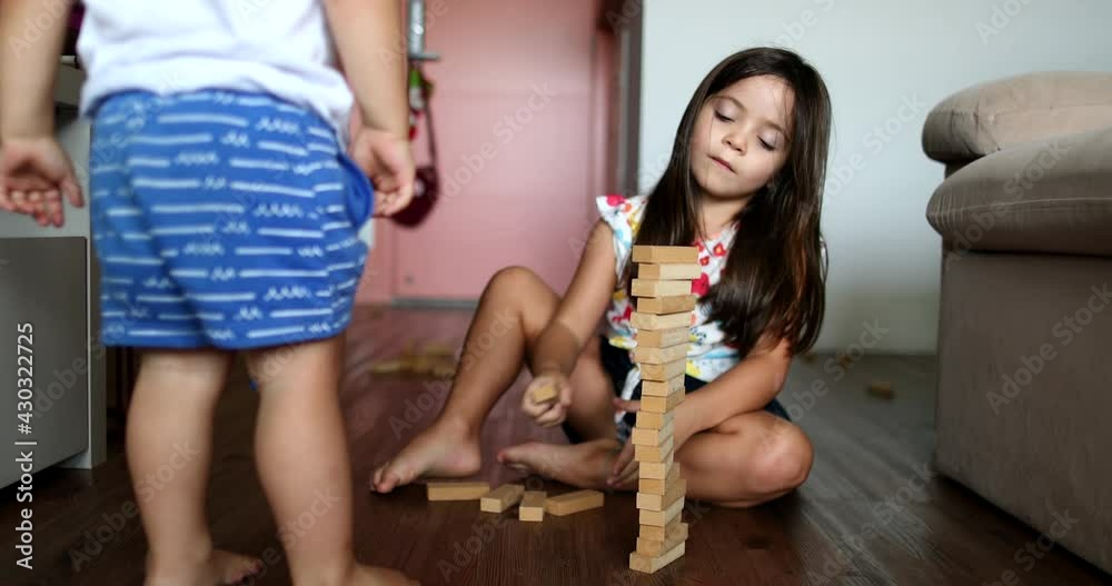 Little girl playing with building wooden blocks at home