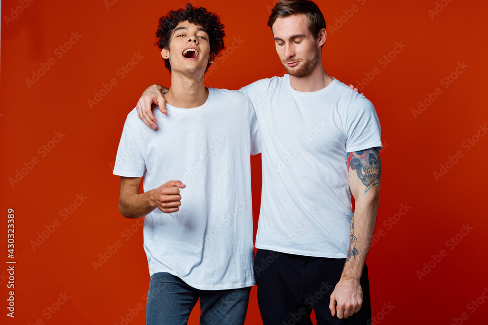 Two cheerful friends in white T-shirts are standing next to team emotions