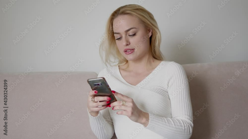 Young woman using smartphone on sofa Young woman using smartphone on sofa