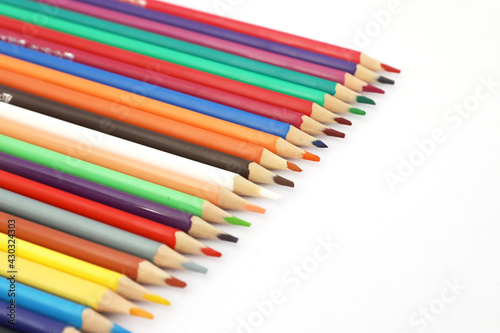 Close-up, colored pencils arranged in a row, white background