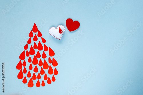 Fototapeta Naklejka Na Ścianę i Meble -  many drops of blood in the form of a drop on a blue background, world blood donor day, charity and care, blood donation