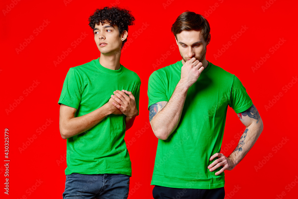 two friends in green t-shirts communication lifestyle red background two friends in green t-shirts communication lifestyle red background
