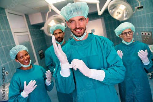 Portrait of successful team of surgeon standing in operating room, ready to work