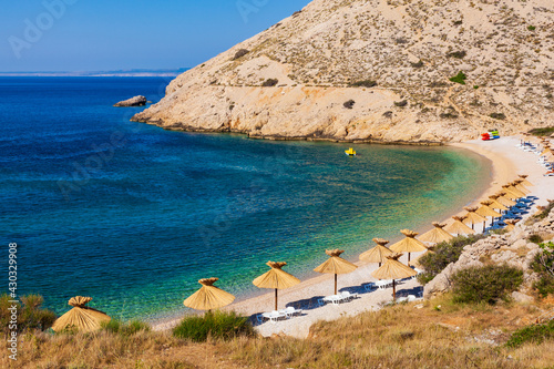 Fototapeta Naklejka Na Ścianę i Meble -  Straw umbrellas in the beautiful Oprna beach in the Krk island