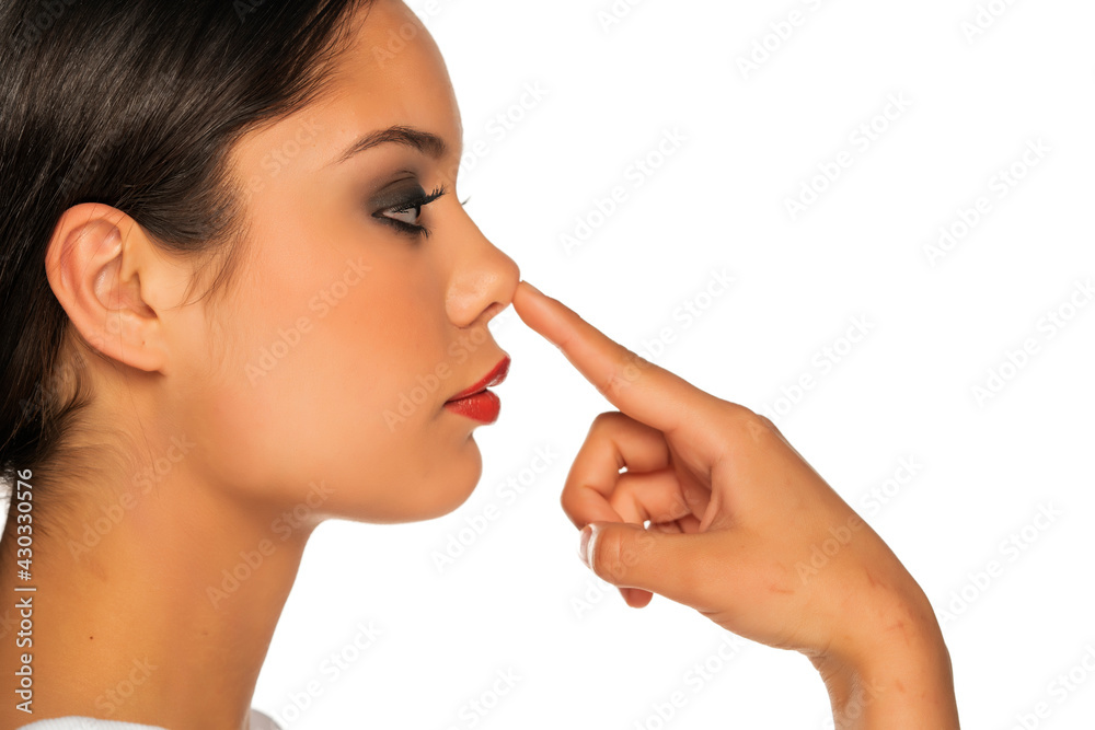 a young beautiful woman touches her nose a young beautiful woman touches her nose