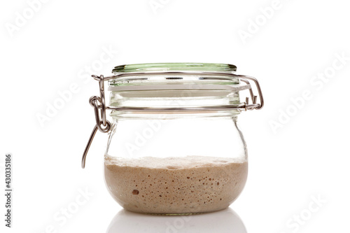 Active sourdough starter in a glass jar for homemade bread. photo