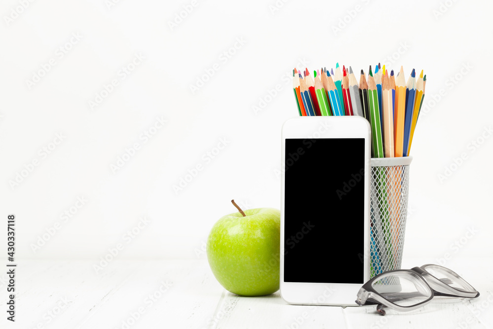 Naklejka premium Workplace with smartphone, supplies and apple