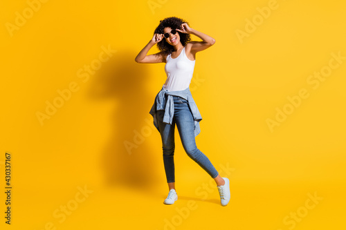 Full length photo of dark skin happy woman wear glasses tight waist jacket isolated on bright yellow color background